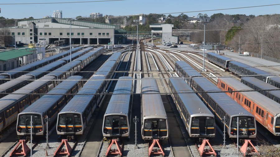 A group of silver MARTA train-cars sit together in a large railway junction.