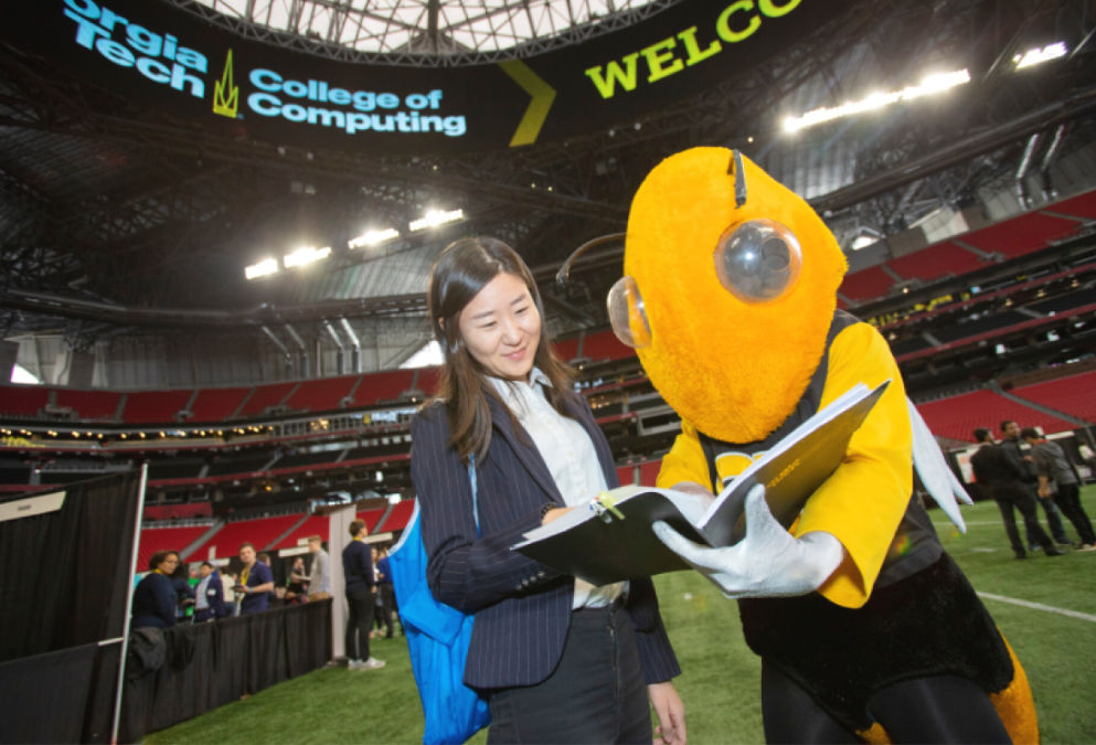 An image of a girl looking at a resume binder with the Georgia Tech Mascot Yellow Jacket