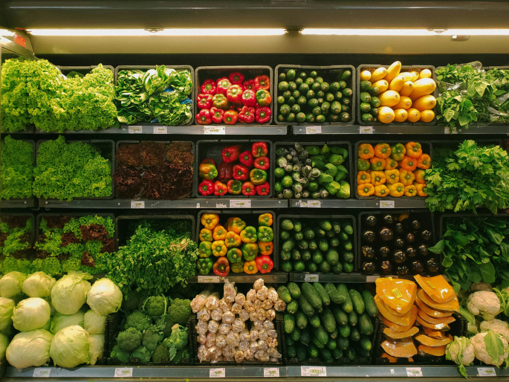 Image of a grocery store, focusing on a section filled with vegetables.