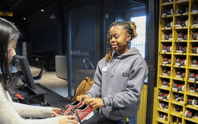 Student employee assisting a customer at the Tech Rec desk inside the Georgia Tech Student Center.