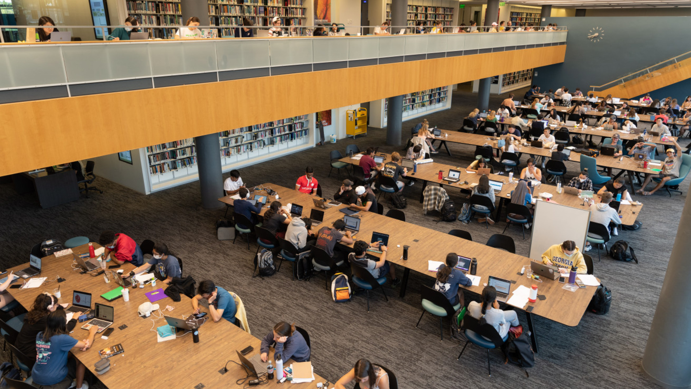 An image showing the third floor of Price Gilbert. It is very busy, and groups of students share large tables which allow for group studying.