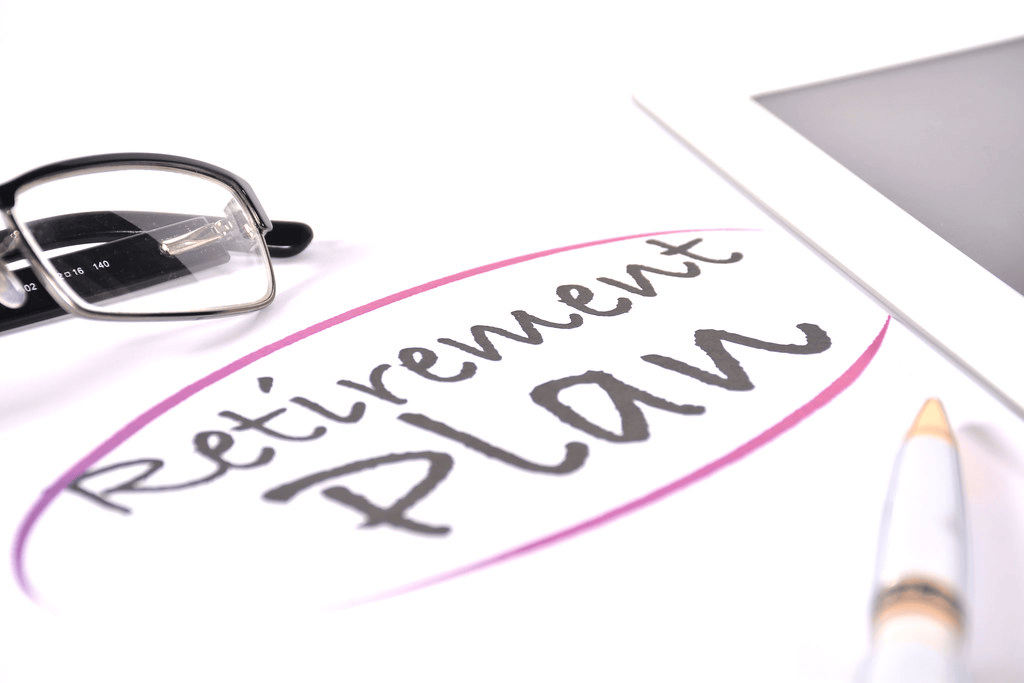 Stock Image with glasses and pen on top of paper with the text “Retirement Plan” circled